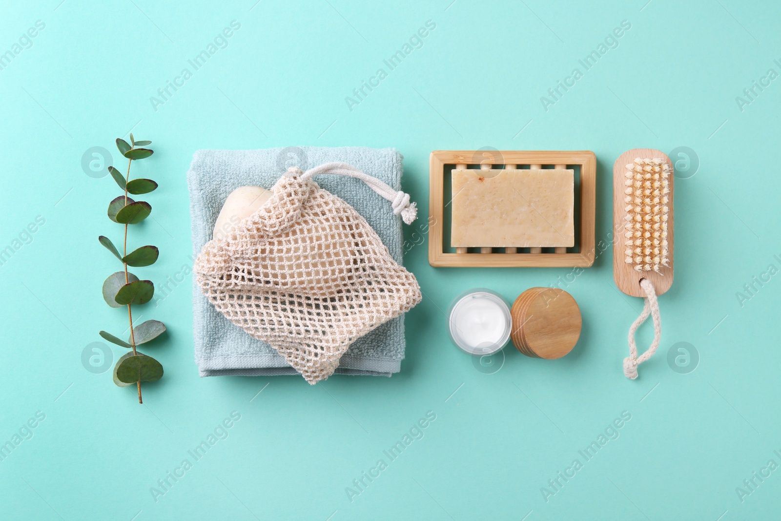 Photo of Jar of cream, body care products and eucalyptus branch on turquoise background, flat lay