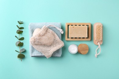 Photo of Jar of cream, body care products and eucalyptus branch on turquoise background, flat lay