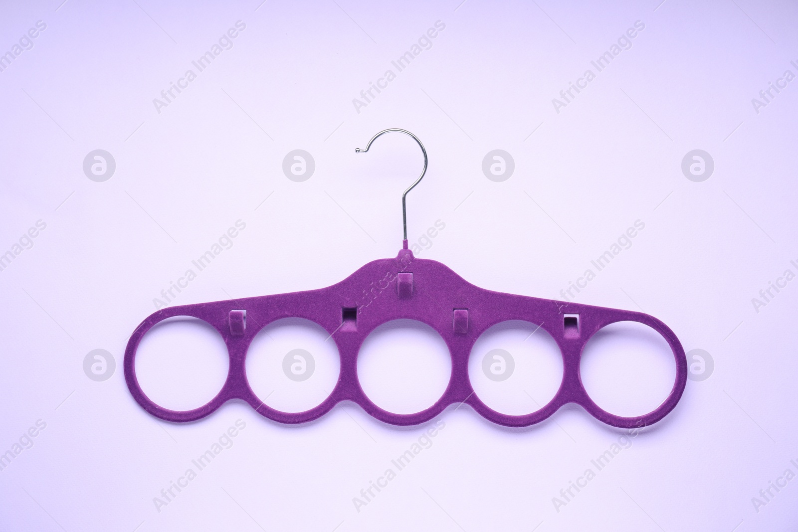 Photo of Empty purple scarf hanger on lilac background, top view