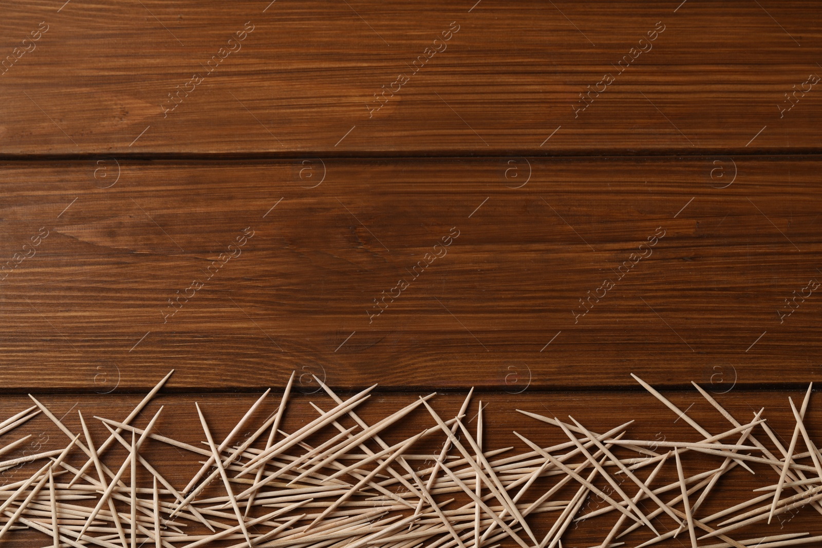 Photo of Disposable toothpicks on wooden background, flat lay. Space for text