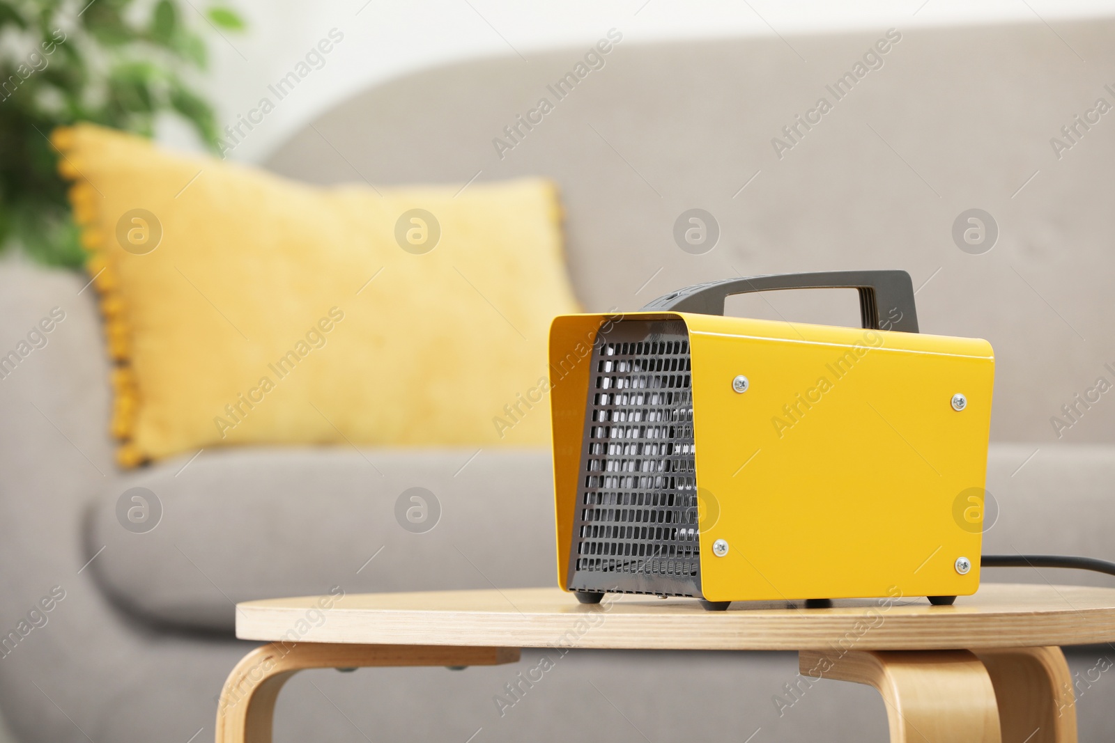 Photo of Modern electric fan heater on coffee table in cozy room. Space for text
