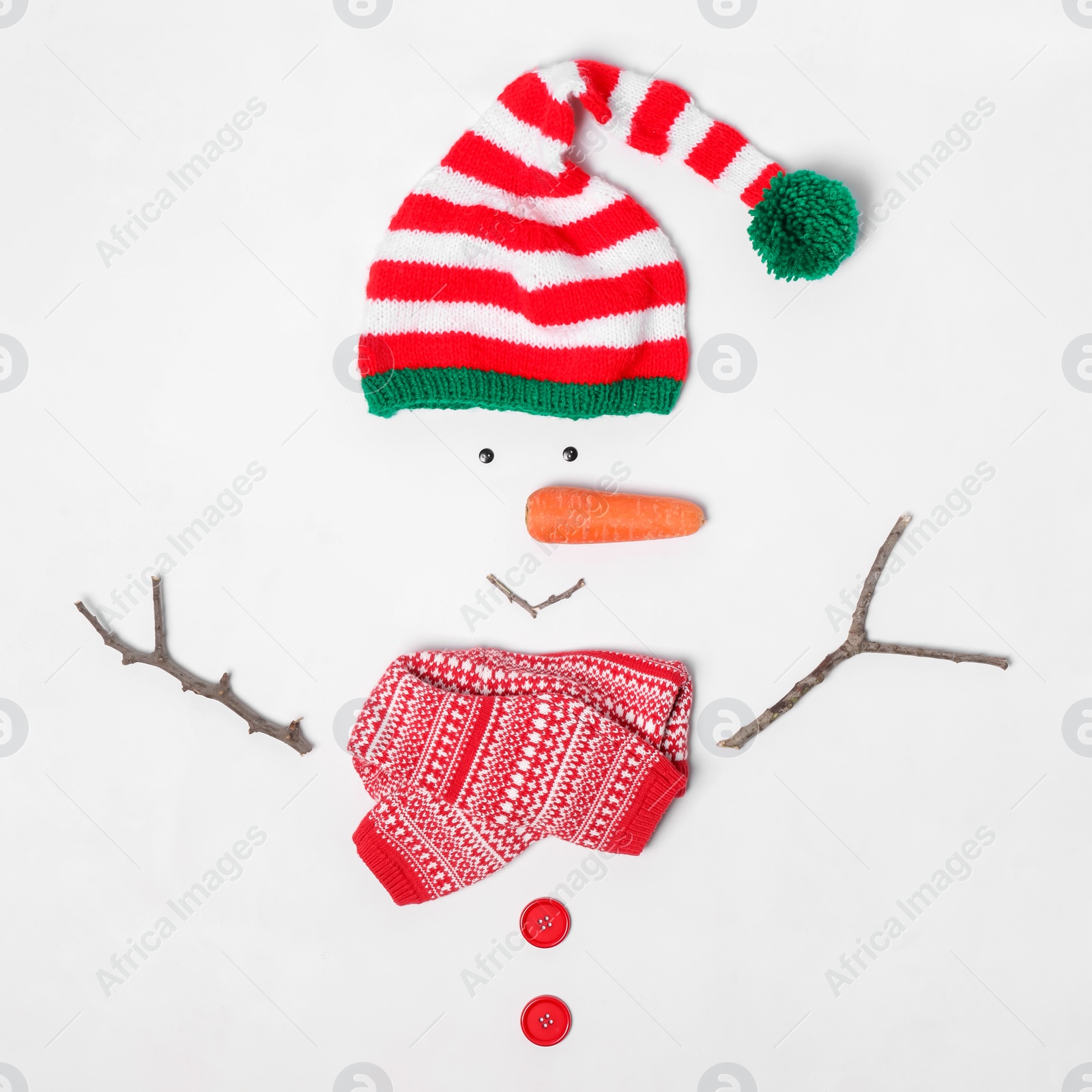 Photo of Creative snowman shape made of Santa elf's hat and different items on white background, flat lay