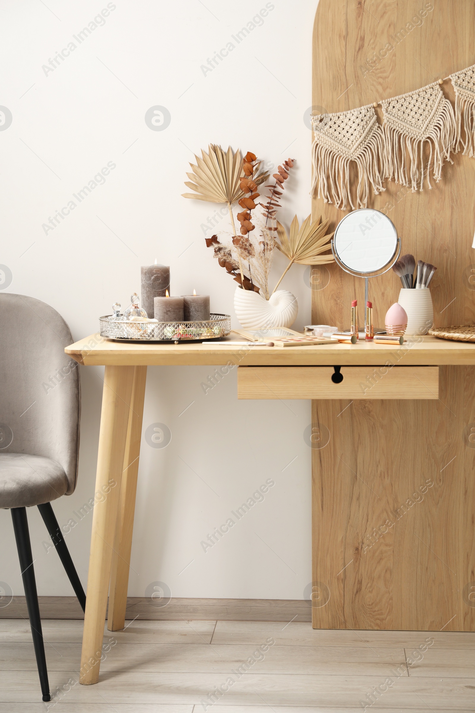 Photo of Dressing table with mirror, makeup products and decor in room