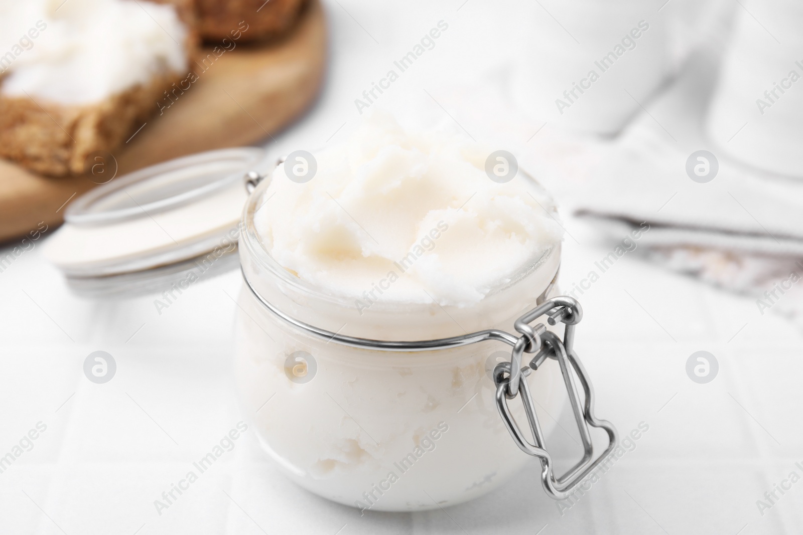Photo of Delicious pork lard in glass jar on white table, closeup