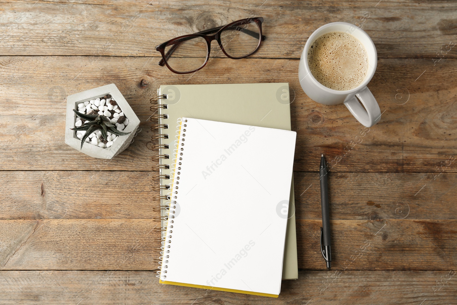 Photo of Flat lay composition with office stationery and cup of coffee on wooden table. Space for design