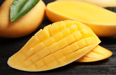 Ripe juicy mango on wooden table, closeup