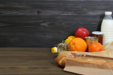 Photo of Different donation food on wooden table, closeup. Space for text