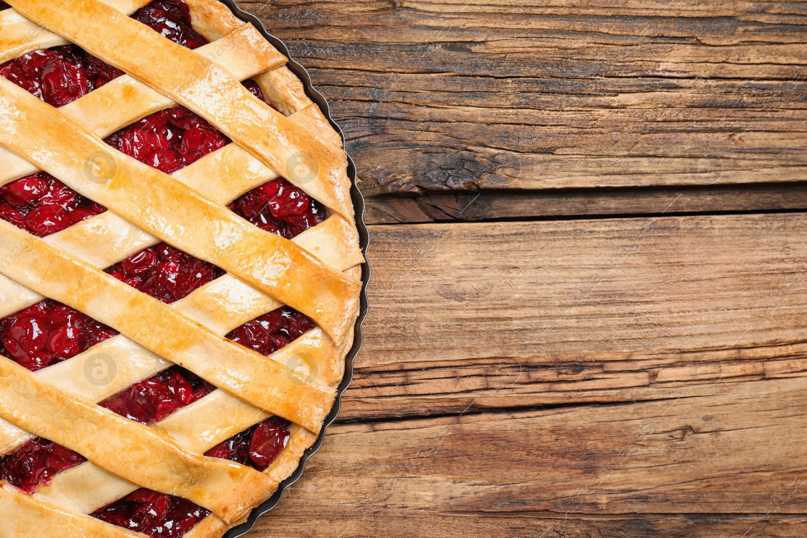 Photo of Delicious fresh cherry pie on wooden table, top view. Space for text