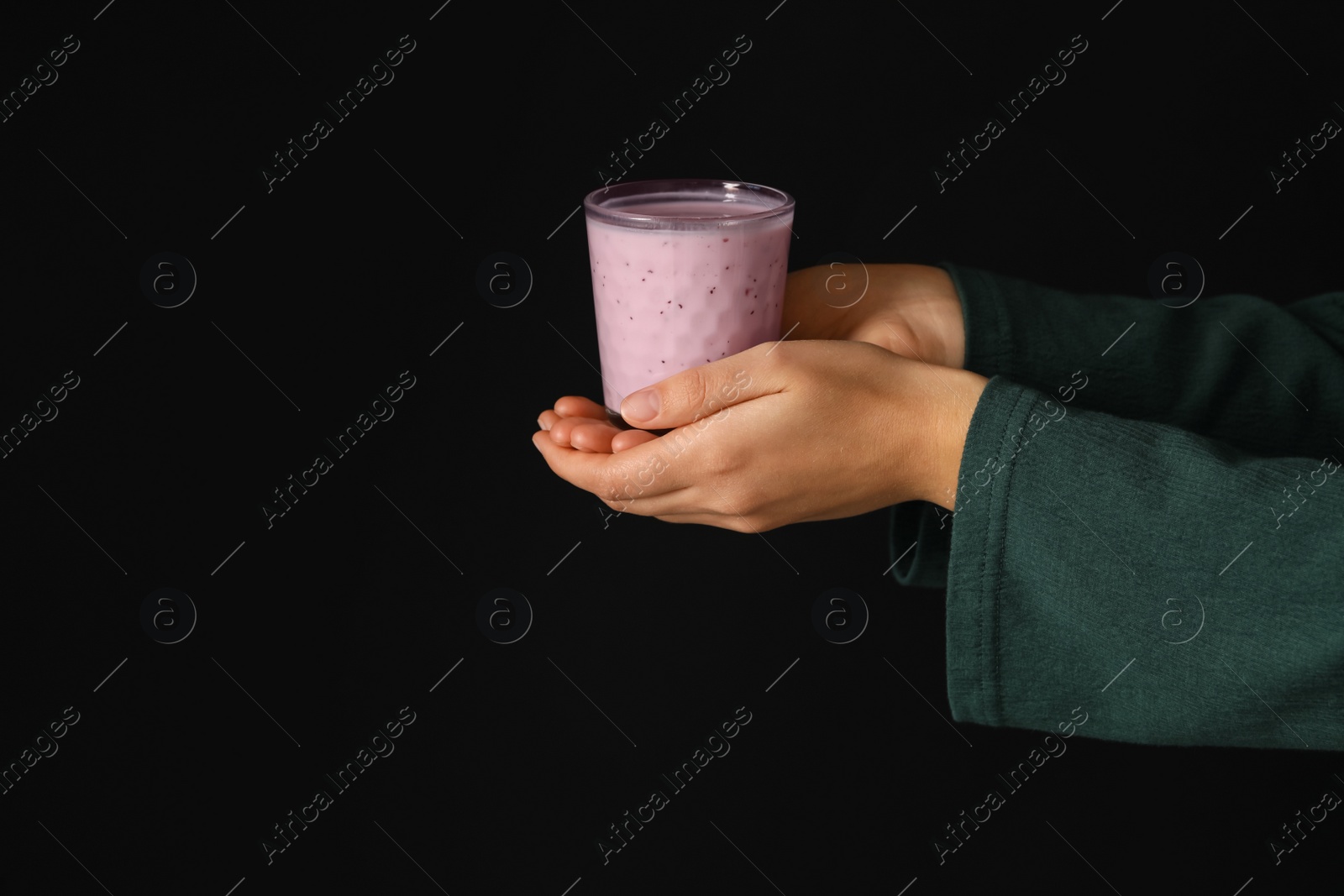 Photo of Woman holding fig smoothie on black background, closeup
