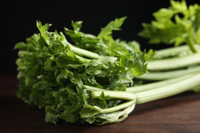 Photo of Fresh ripe green celery on wooden table, closeup