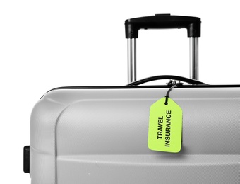 Photo of Grey suitcase with TRAVEL INSURANCE label on white background, closeup