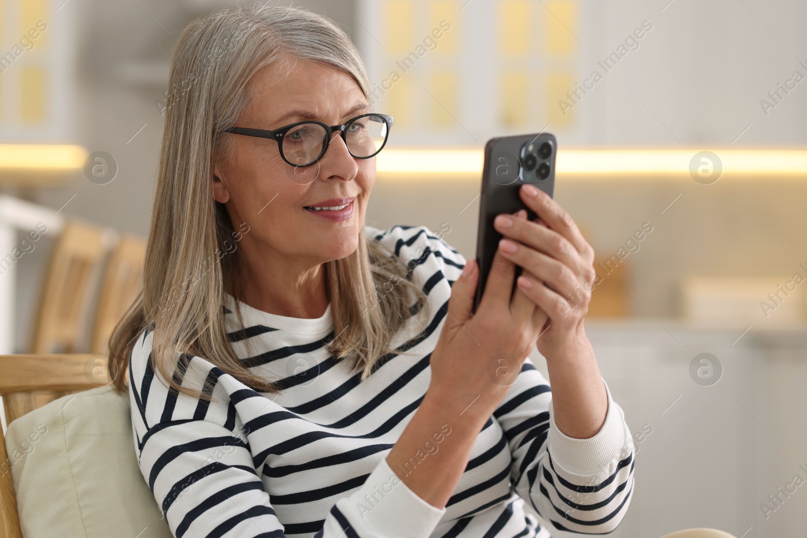 Photo of Senior woman using mobile phone at home