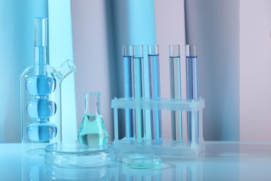 Laboratory analysis. Different glassware on table against color background