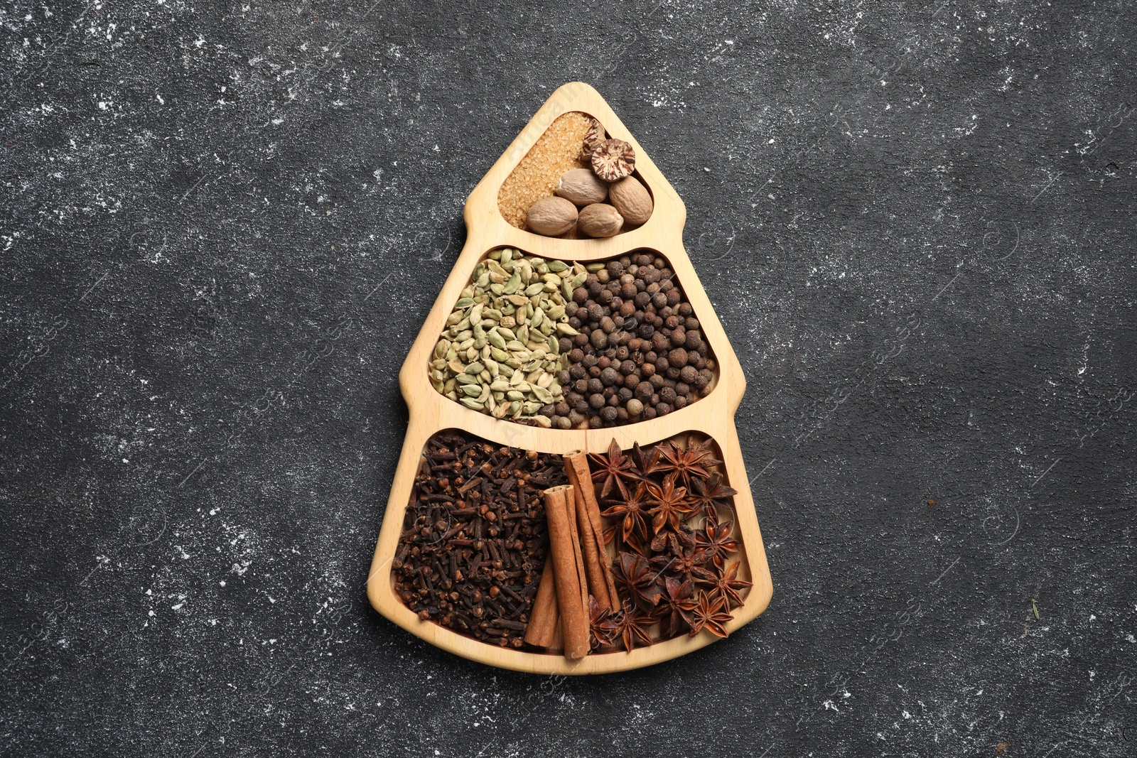 Photo of Different spices and nuts on dark gray textured table, top view