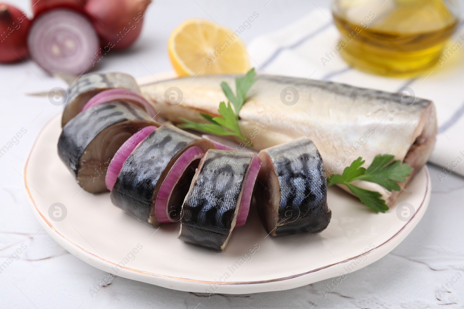 Photo of Tasty salted mackerel parsley and onion on white textured table, closeup