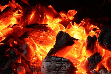 Pieces of hot smoldering coal as background, closeup