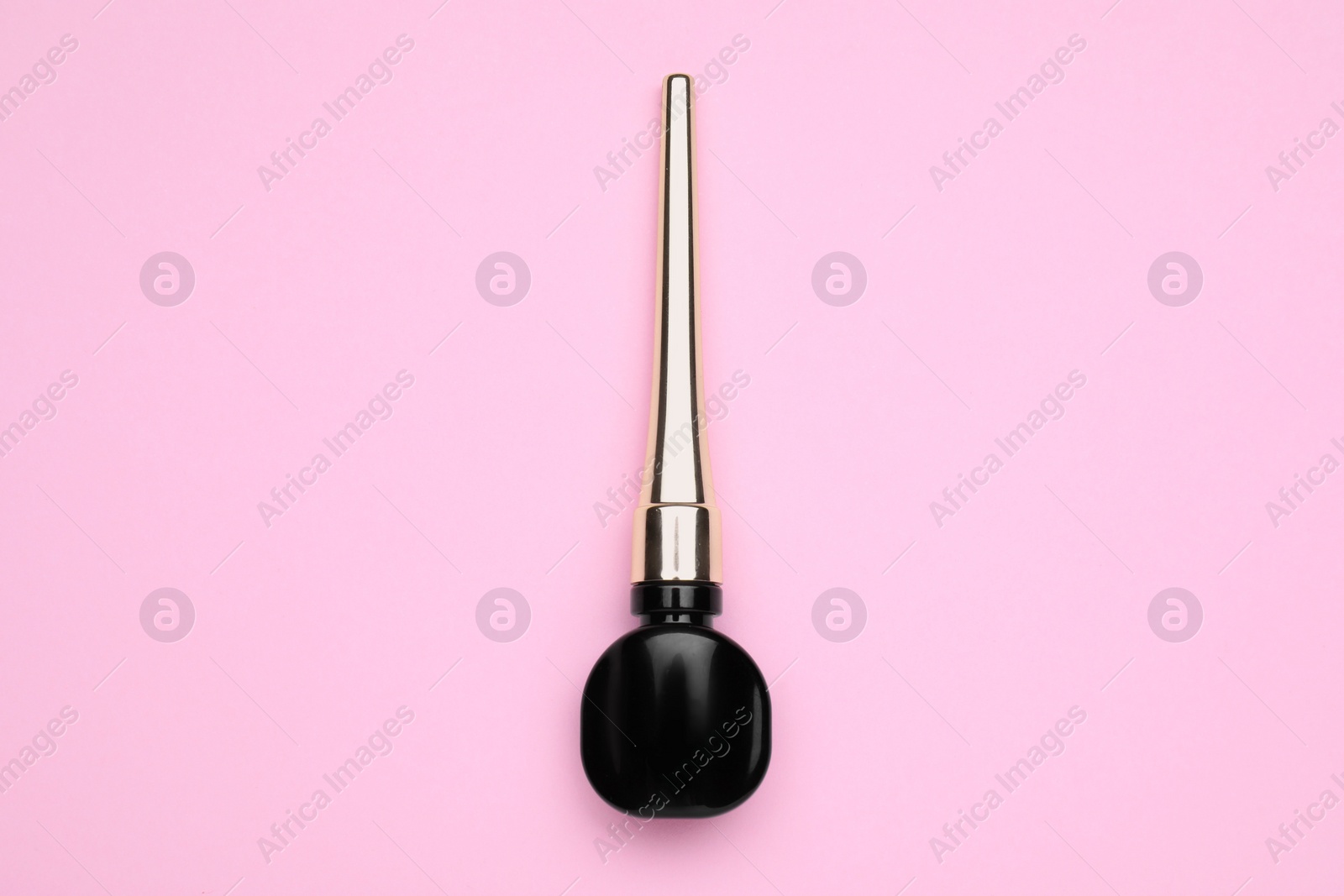 Photo of Black eyeliner on pink background, top view. Makeup product