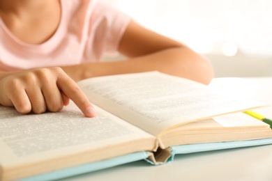 Photo of Little girl doing homework at table, closeup