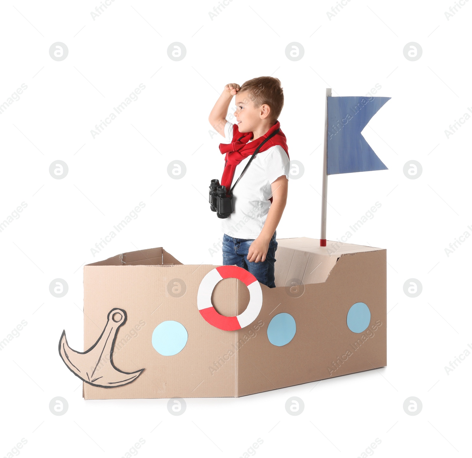 Photo of Cute little boy playing with cardboard ship on white background