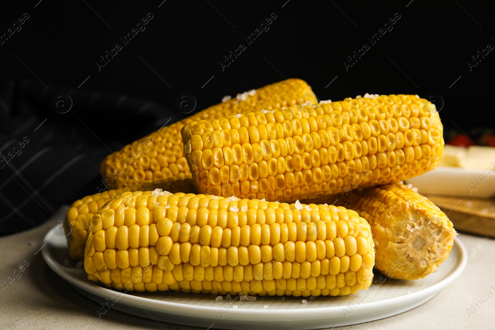 Photo of Delicious boiled corn with salt on table