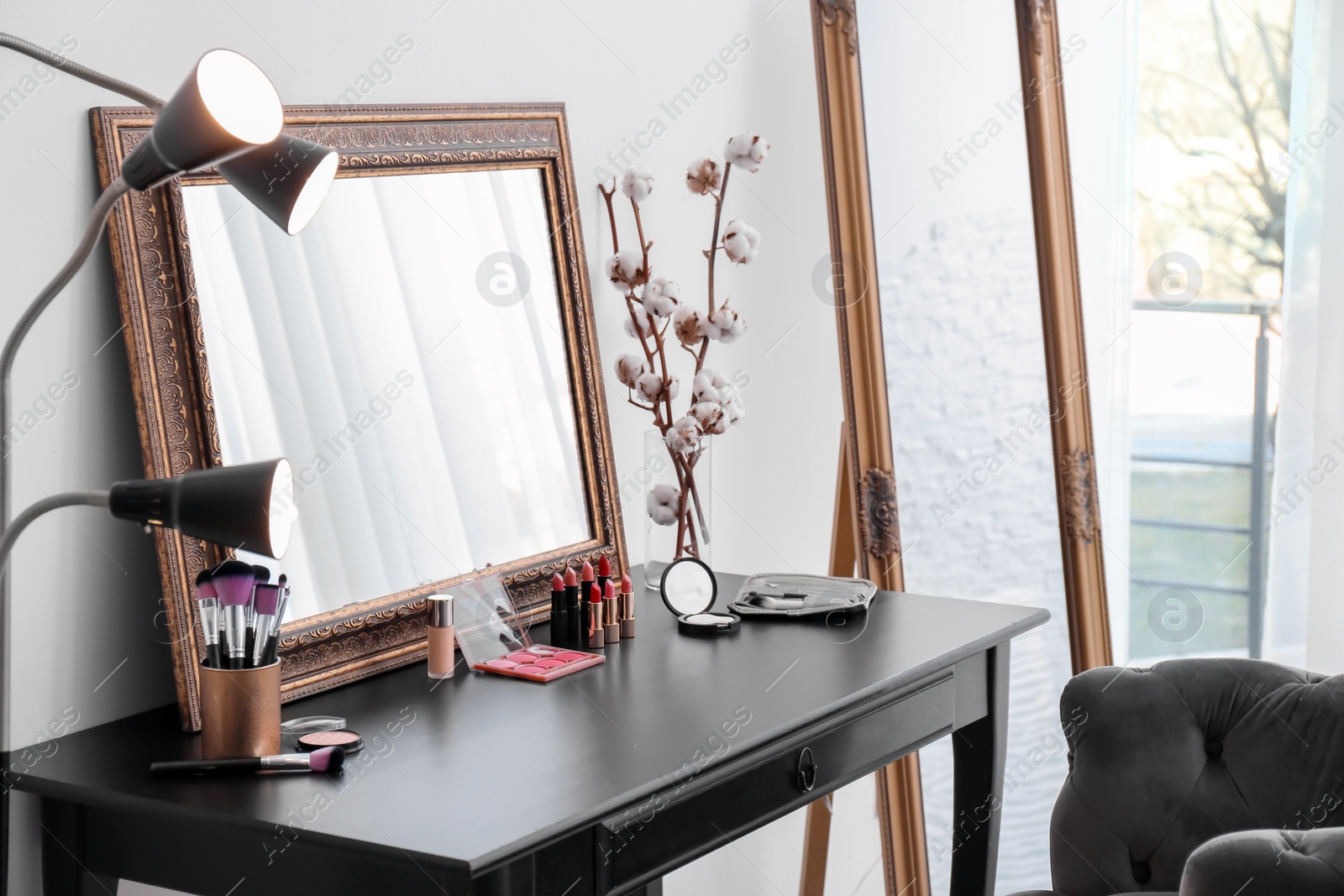 Photo of Decorative cosmetics and tools on dressing table near mirror in makeup room