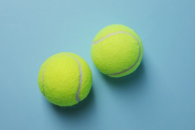 Photo of Two tennis balls on light blue background, top view