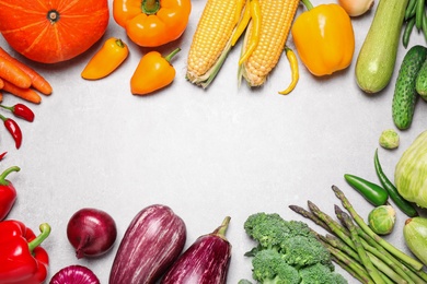 Photo of Frame of different fresh vegetables on grey table, flat lay. Space for text