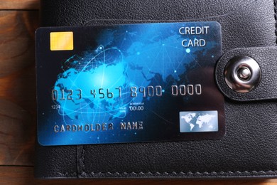 Credit card and leather wallet on wooden table, top view