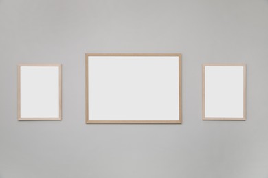 Photo of Empty frames on grey wall. Mockup for design