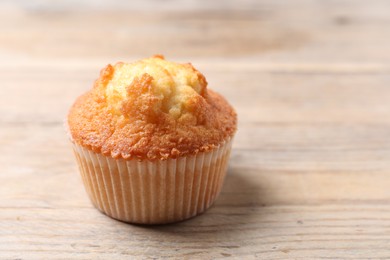 Photo of Delicious sweet muffin on wooden table, closeup. Space for text