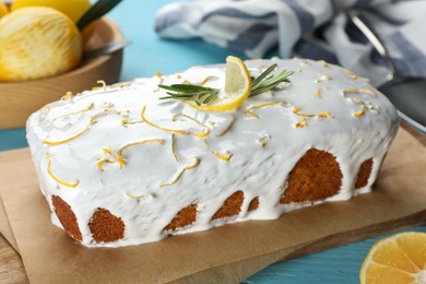 Photo of Tasty lemon cake with glaze on light blue wooden table, closeup