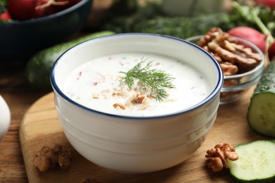 Photo of Delicious cold summer soup on wooden board, closeup