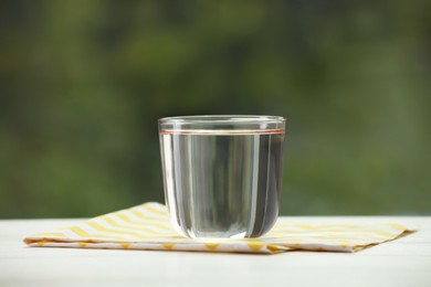 Photo of Glass of pure water on white table