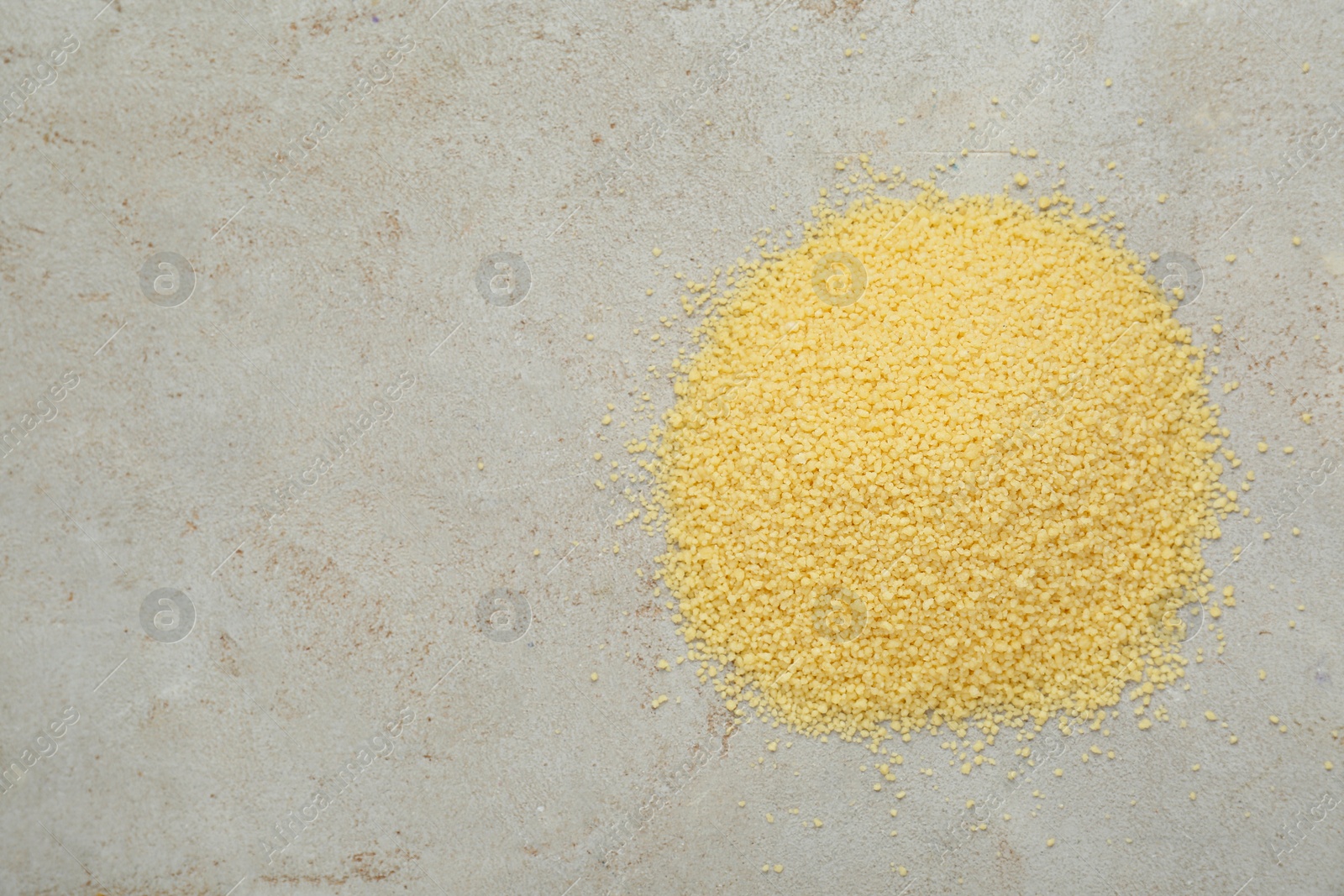 Photo of Heap of raw couscous on light table, top view. Space for text