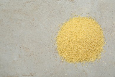 Photo of Heap of raw couscous on light table, top view. Space for text