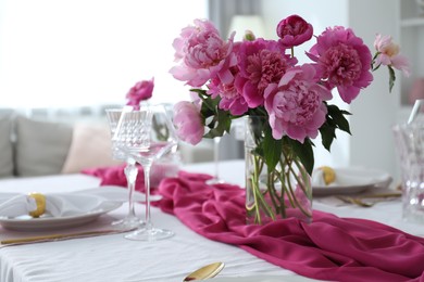 Photo of Beautiful table setting with pink peonies in dining room