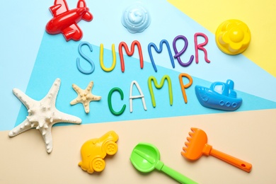 Photo of Flat lay composition with text SUMMER CAMP made of modelling clay on color background