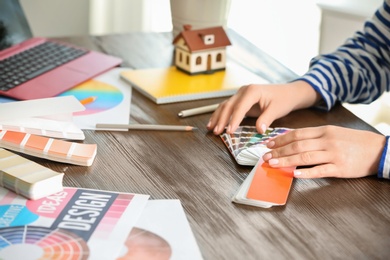 Female designer working with color palette samples at table