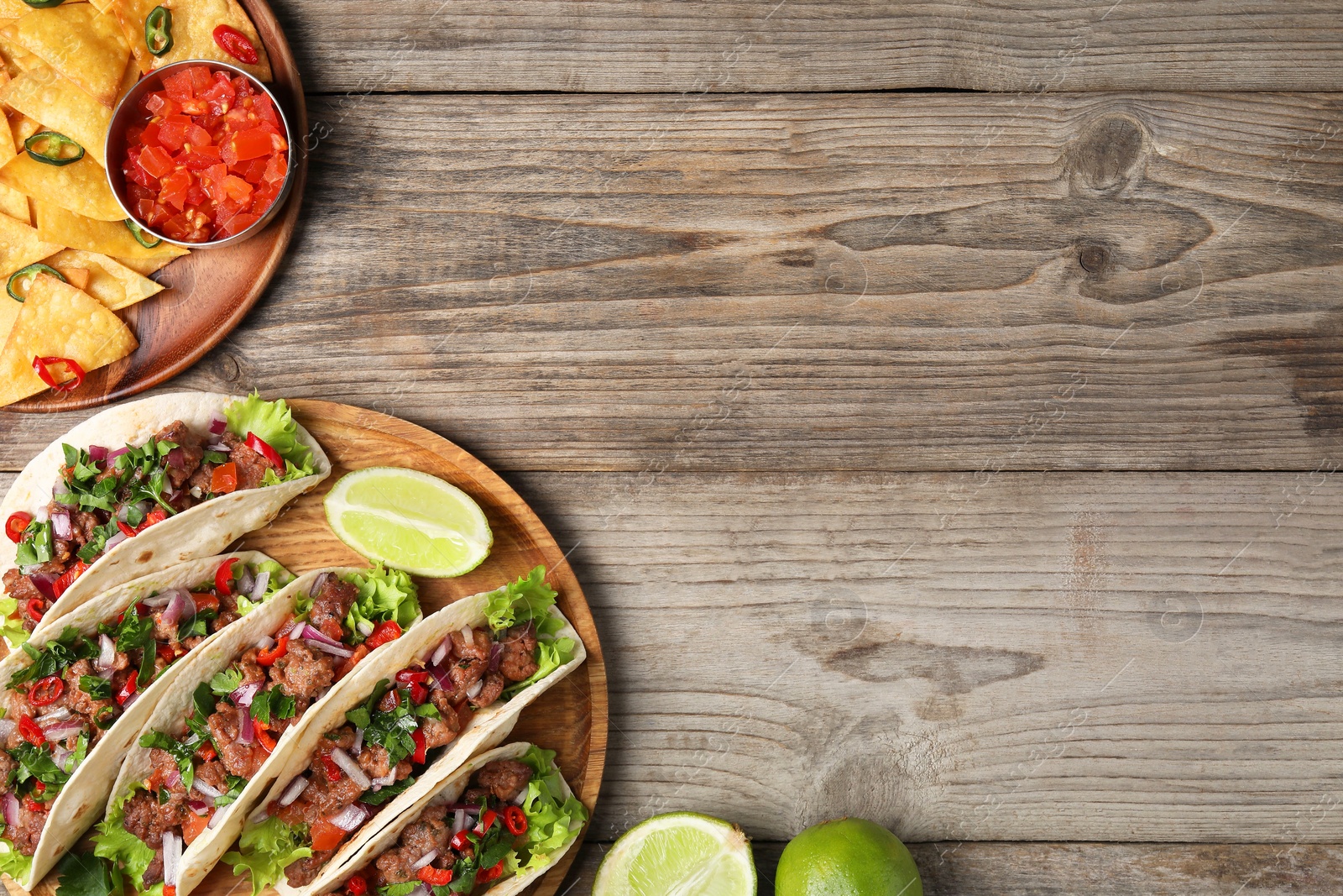 Photo of Flat lay composition with delicious tacos on wooden table, space for text