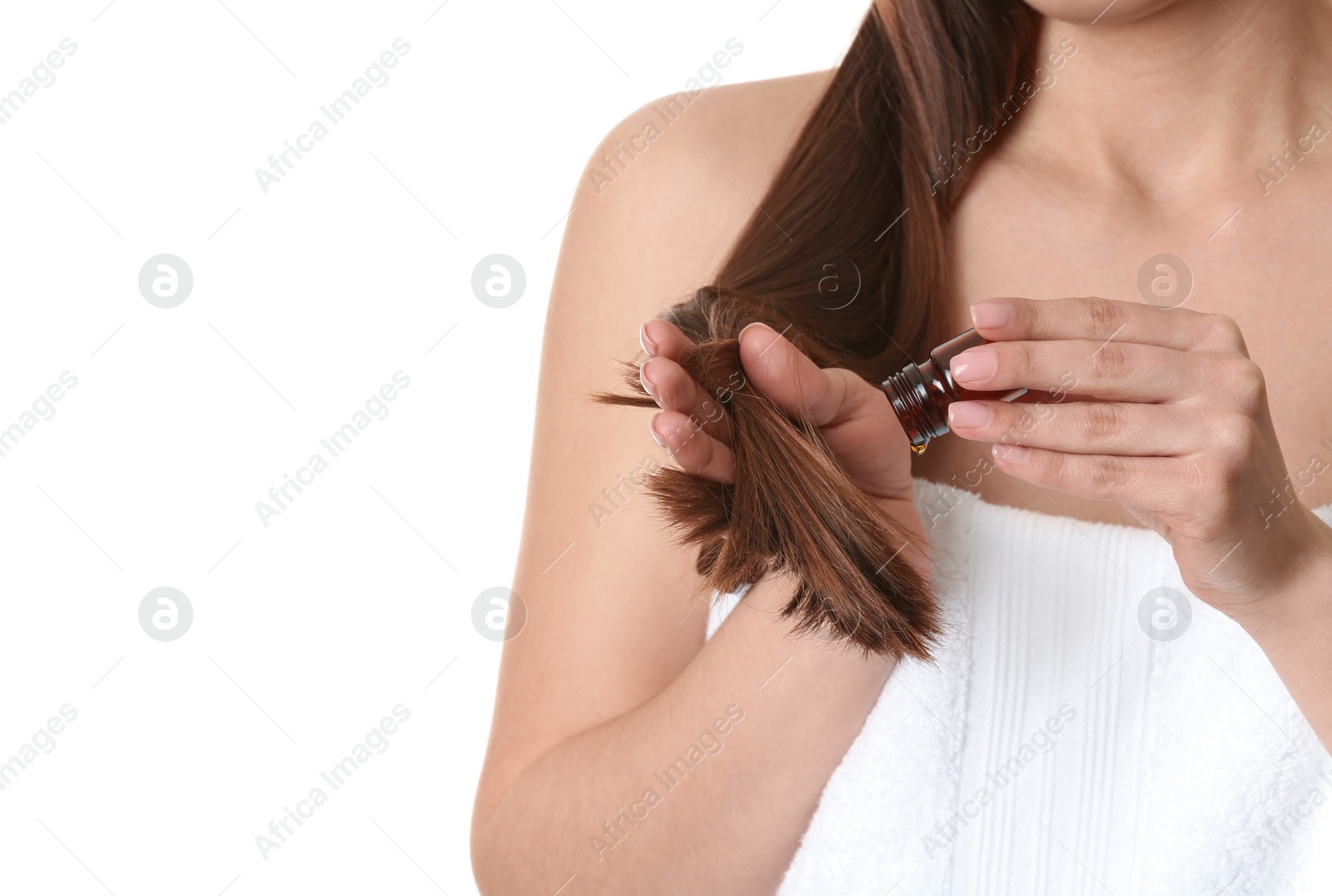 Photo of Woman applying oil onto hair against white background, closeup