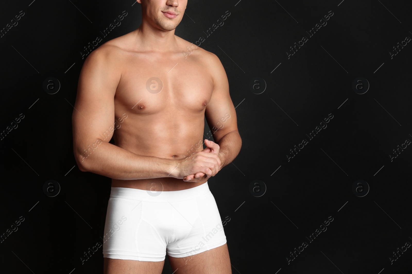 Photo of Man with sexy body on black background, closeup. Space for text