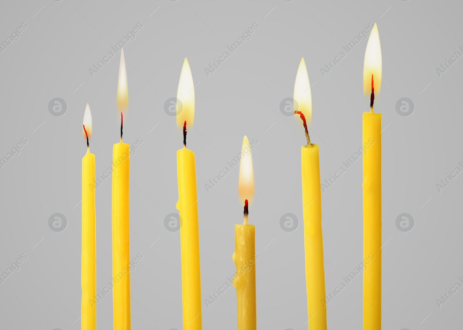 Image of Many burning church candles on light background