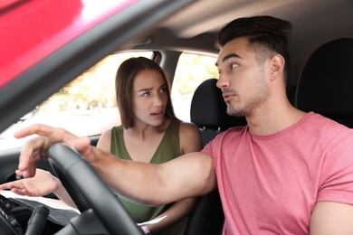 Photo of Young couple arguing in car front seats