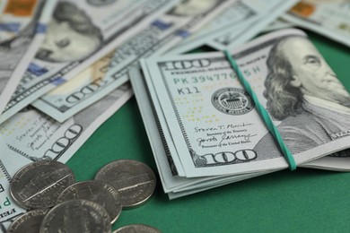 Money exchange. Dollar banknotes and coins on green background, closeup