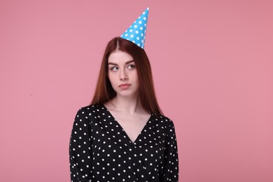 Photo of Sad woman in party hat on pink background