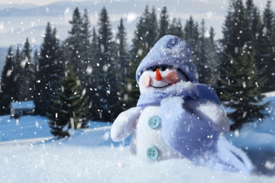 Image of Cute small decorative snowman outdoors on sunny day, space for text