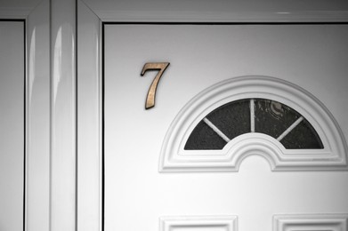 Photo of House number seven on white wooden door