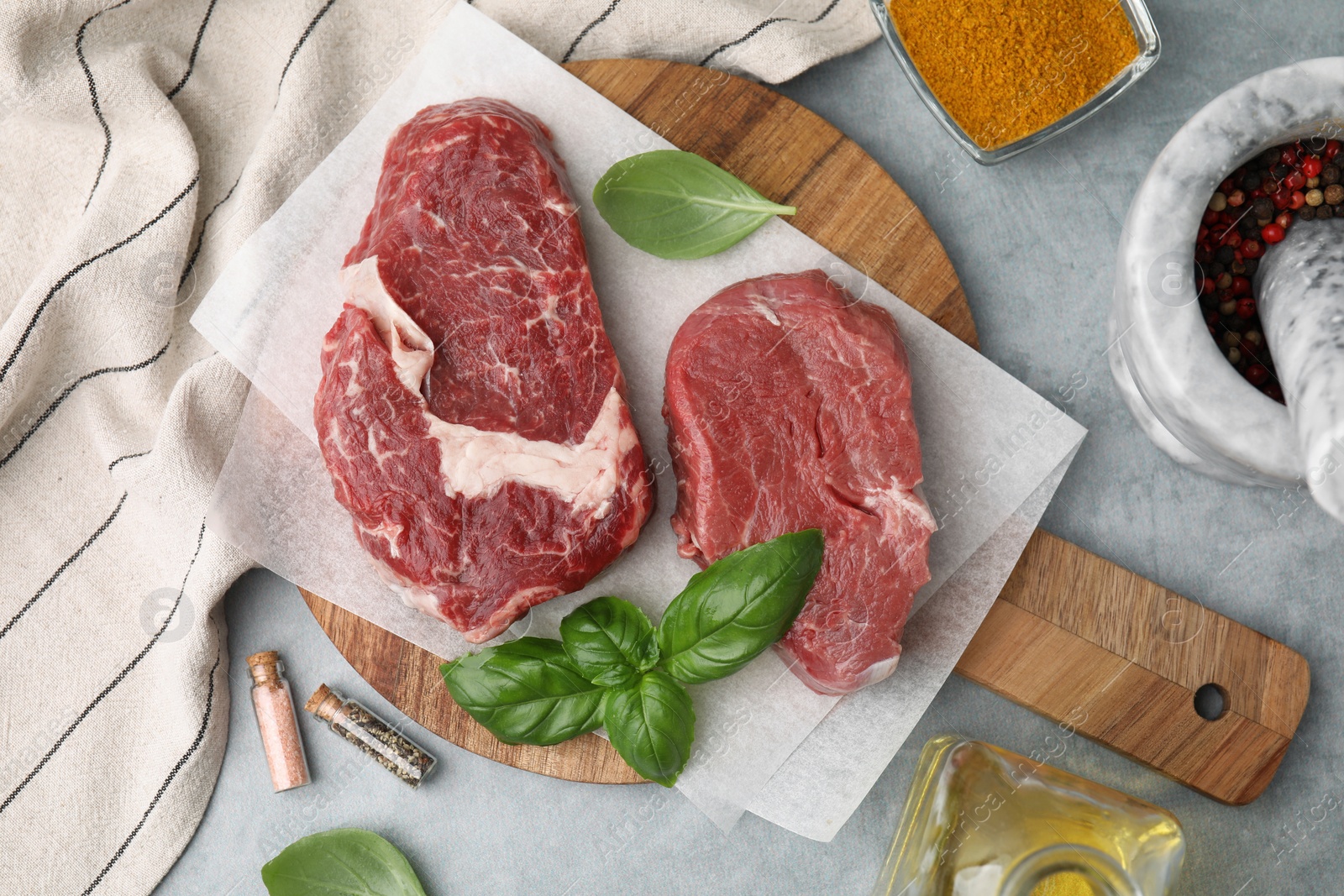 Photo of Flat lay composition with cut fresh beef meat on grey table