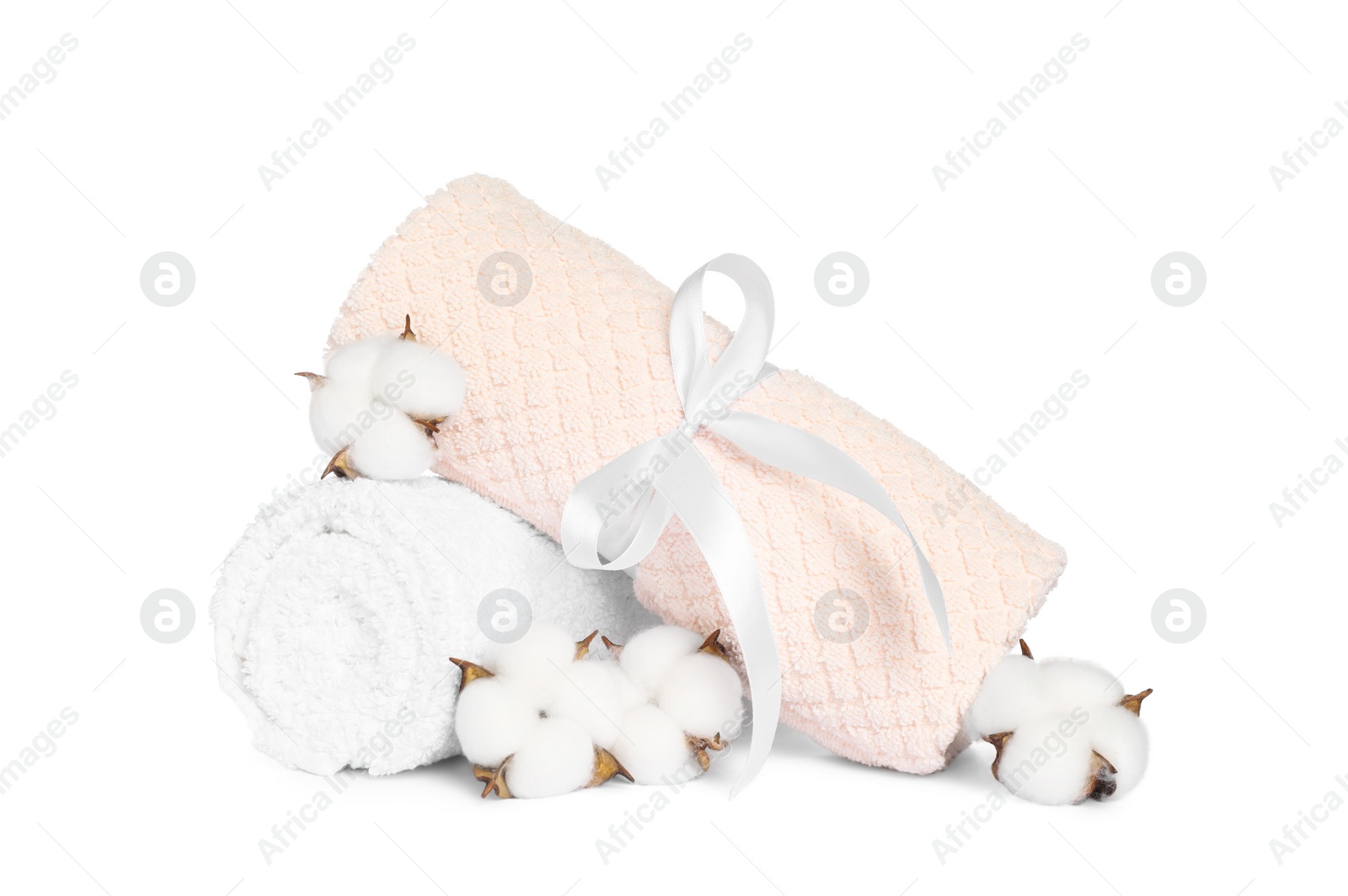 Photo of Clean soft towels with cotton flowers isolated on white