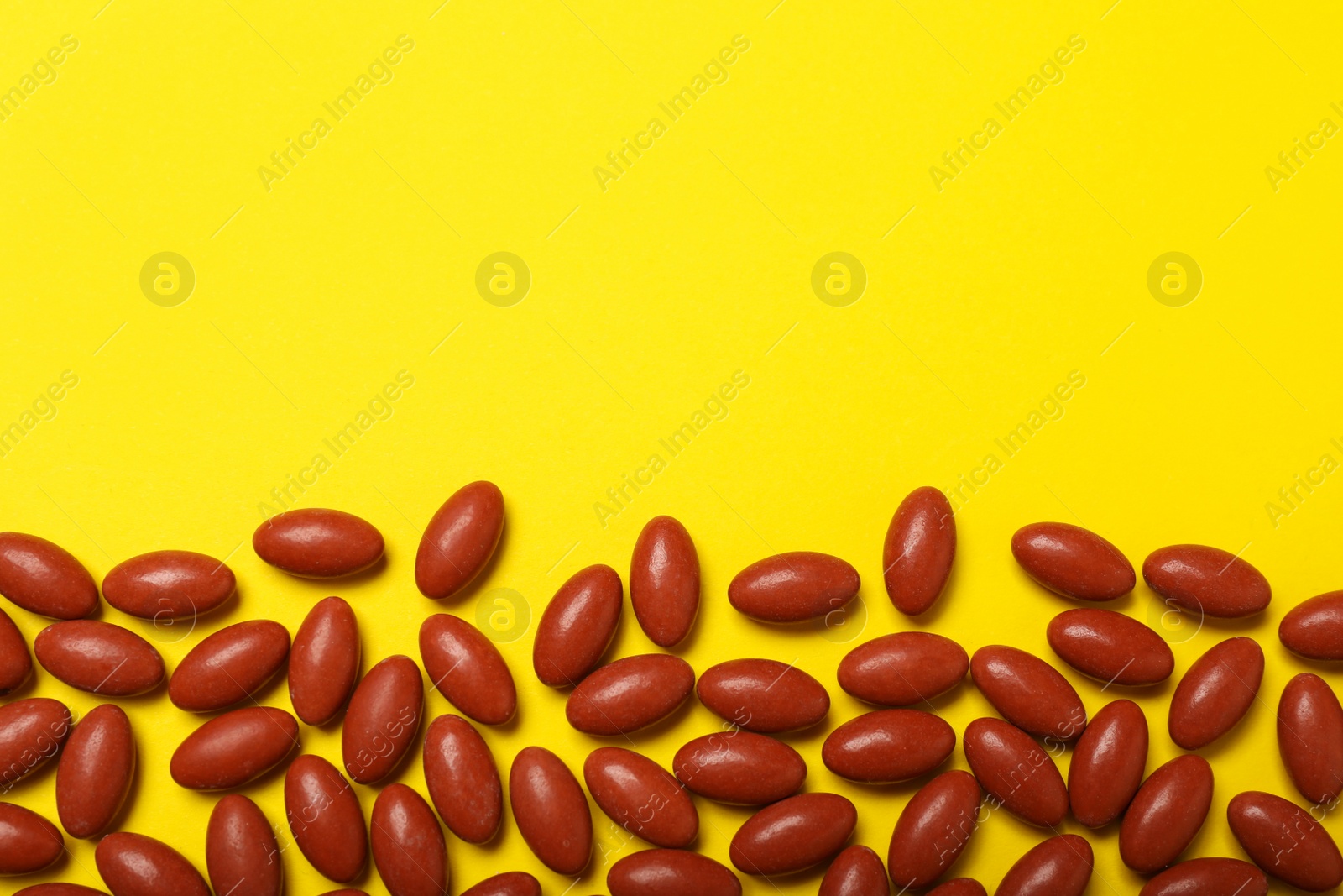 Photo of Many pills on yellow background, flat lay with space for text